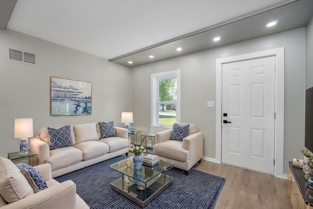 living room featuring light wood-type flooring, visible vents, and recessed lighting