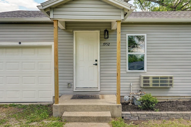 property entrance with a shingled roof and a garage