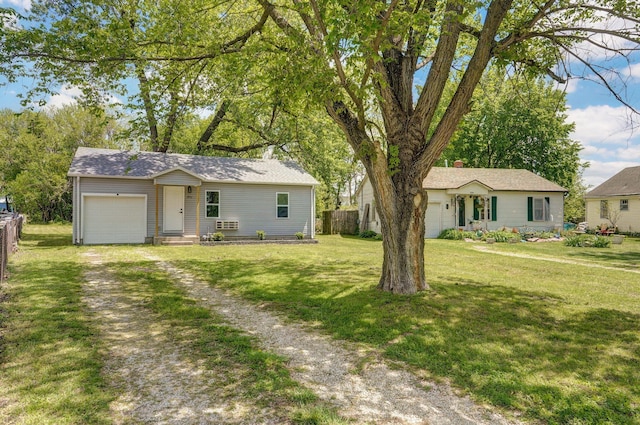 ranch-style house featuring an attached garage, fence, a front yard, and driveway