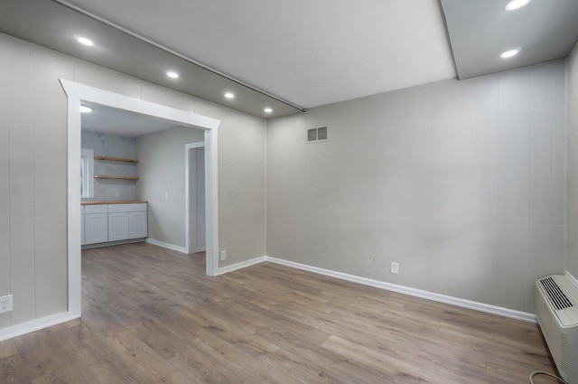 below grade area with light wood-style flooring, baseboards, visible vents, and recessed lighting