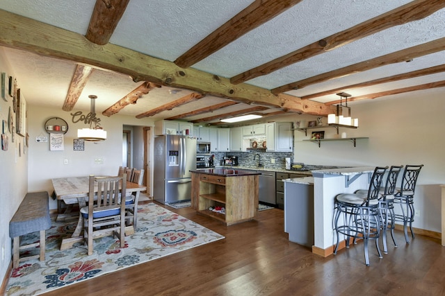 kitchen featuring a peninsula, stainless steel appliances, open shelves, and a textured ceiling