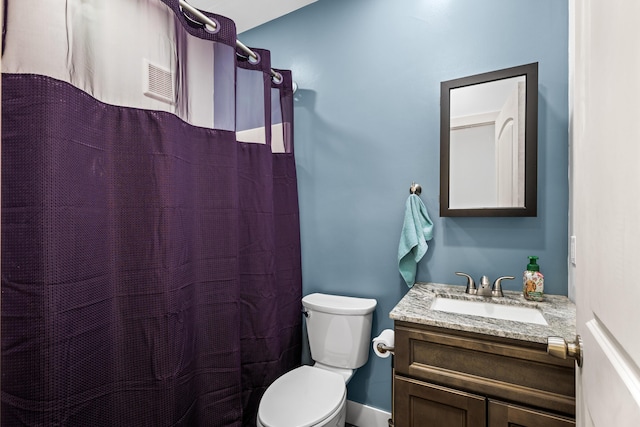 bathroom with toilet, vanity, and a shower with curtain