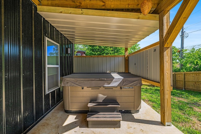 view of patio / terrace with fence and a hot tub