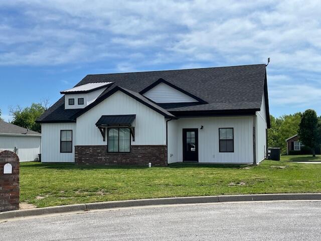 modern farmhouse with a front yard and central AC