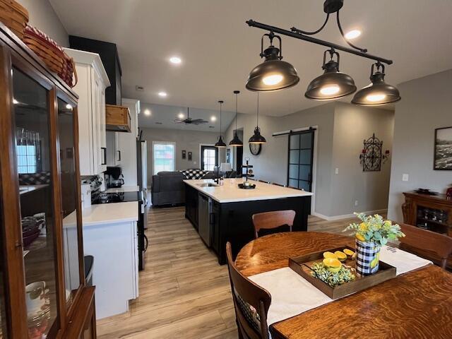 dining room featuring a barn door and light wood-style flooring