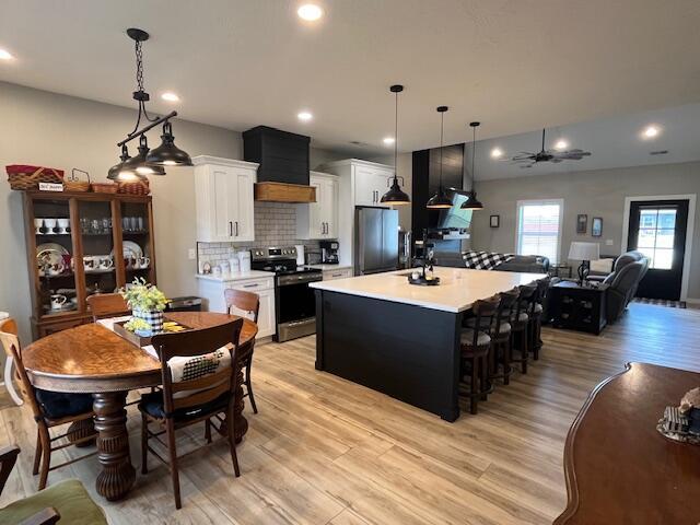 kitchen with electric range, fridge, light wood finished floors, light countertops, and recessed lighting