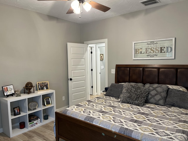 bedroom with light wood-style floors and a ceiling fan