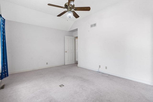 empty room featuring carpet floors, ceiling fan, lofted ceiling, and baseboards