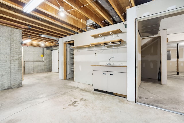unfinished below grade area featuring a sink and brick wall