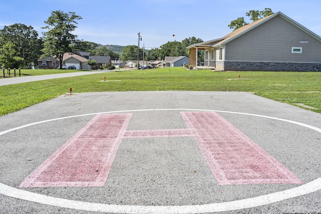 view of sport court featuring a yard