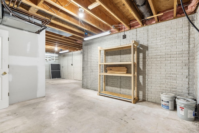 unfinished below grade area featuring brick wall