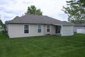 rear view of property with a lawn