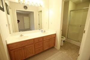 bathroom featuring a stall shower, toilet, and vanity