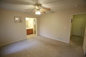 unfurnished bedroom featuring baseboards, carpet flooring, ensuite bath, and a ceiling fan