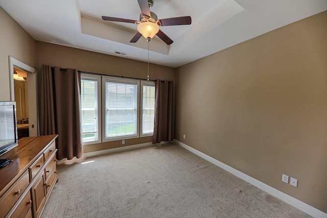 134 Monte Christo Dr, Hollister, MO 65672 - unfurnished bedroom with light carpet, baseboards, a tray ceiling, and a ceiling fan