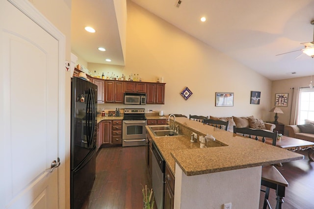 134 Monte Christo Dr, Hollister, MO 65672 - kitchen with stainless steel appliances, a sink, a breakfast bar, dark wood-style floors, and open floor plan