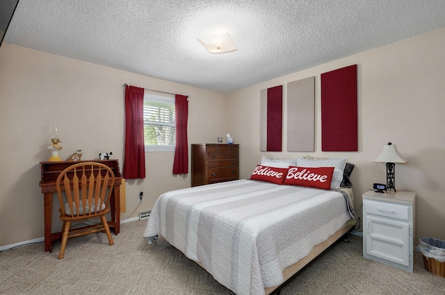 bedroom with light colored carpet and a textured ceiling