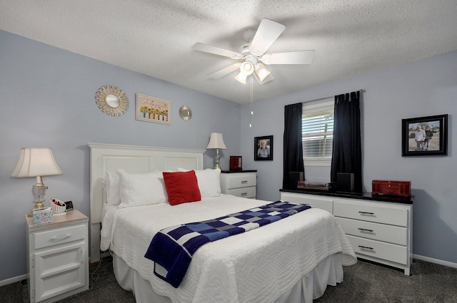 bedroom featuring dark colored carpet, baseboards, a ceiling fan, and a textured ceiling