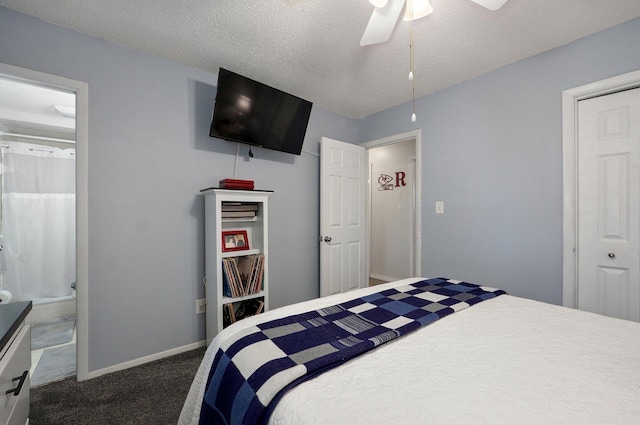 carpeted bedroom with a textured ceiling, baseboards, a ceiling fan, and ensuite bath