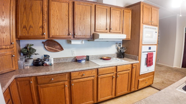 1156 SE 180th Rd, Clinton, MO 64735 - kitchen featuring white appliances, under cabinet range hood, brown cabinets, light countertops, and light colored carpet