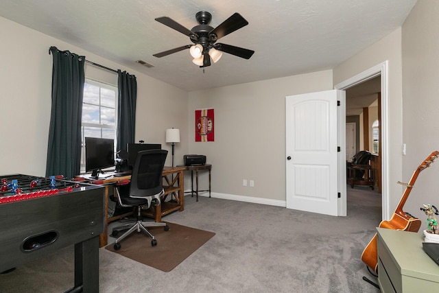 carpeted office featuring a ceiling fan and baseboards