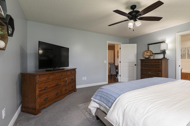 carpeted bedroom featuring ensuite bathroom, baseboards, and a ceiling fan