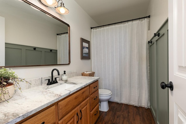 full bathroom featuring wood finished floors, vanity, and toilet