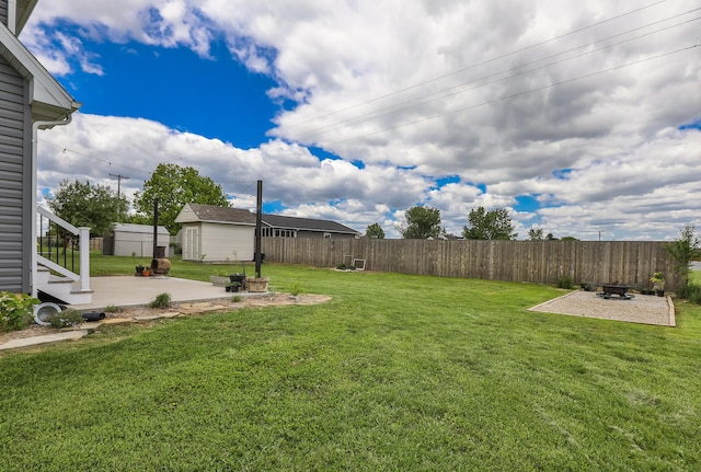 view of yard with a patio area, an outdoor fire pit, an outbuilding, and a storage shed