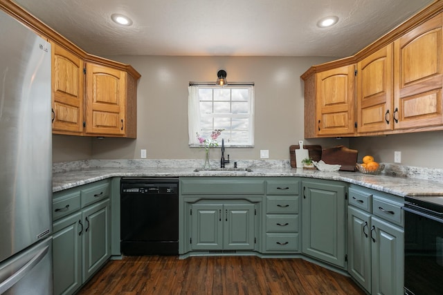 kitchen featuring black appliances, a sink, green cabinets, dark wood finished floors, and a ceiling fan