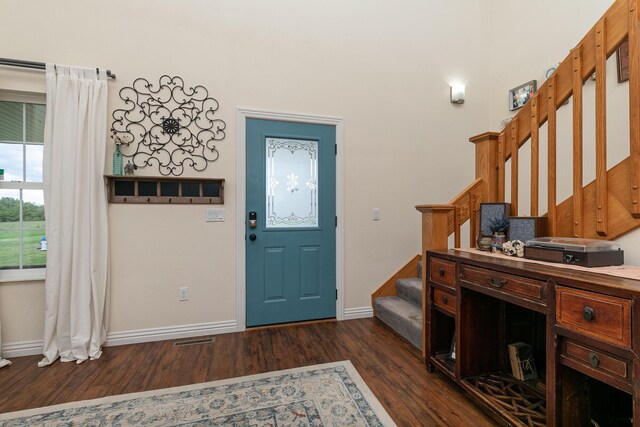 foyer with stairway, dark wood-type flooring, and baseboards
