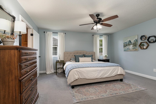 carpeted bedroom with baseboards, ceiling fan, and a textured ceiling