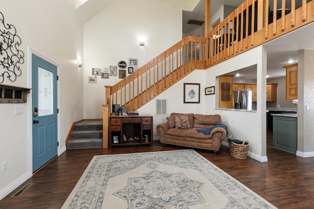 living area featuring stairs, a high ceiling, dark wood-style flooring, and baseboards
