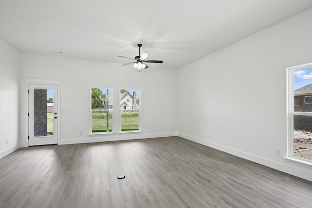 1707 E White Oak Dr, Joplin, MO 64801 - unfurnished living room featuring plenty of natural light, wood finished floors, and a ceiling fan