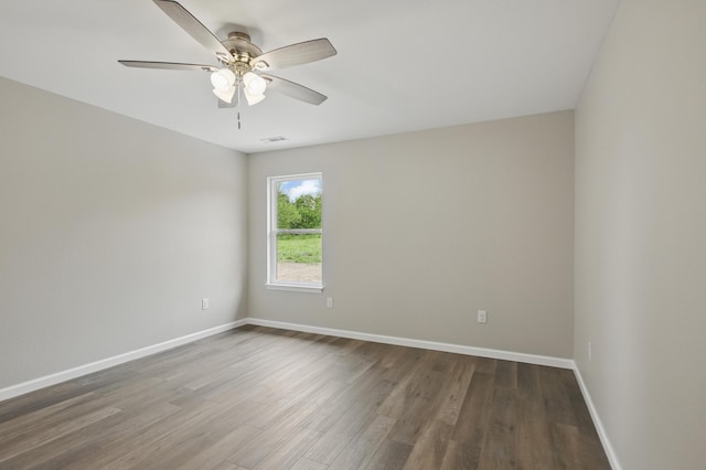empty room with dark wood-type flooring, baseboards, and ceiling fan