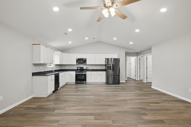 kitchen with stainless steel appliances, dark countertops, a sink, ceiling fan, and recessed lighting