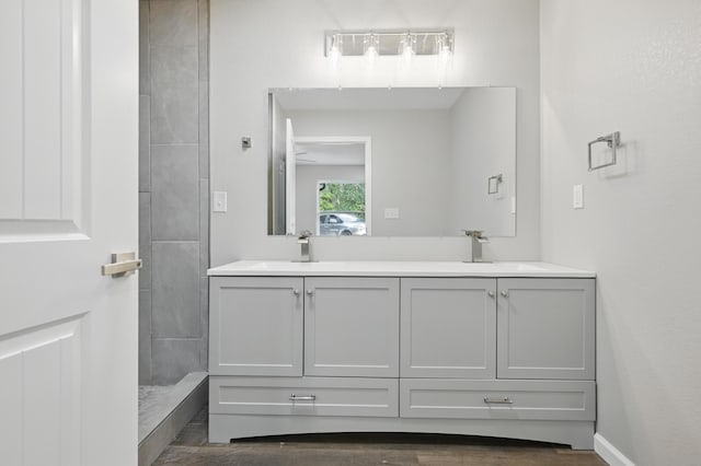 full bath featuring double vanity and tiled shower
