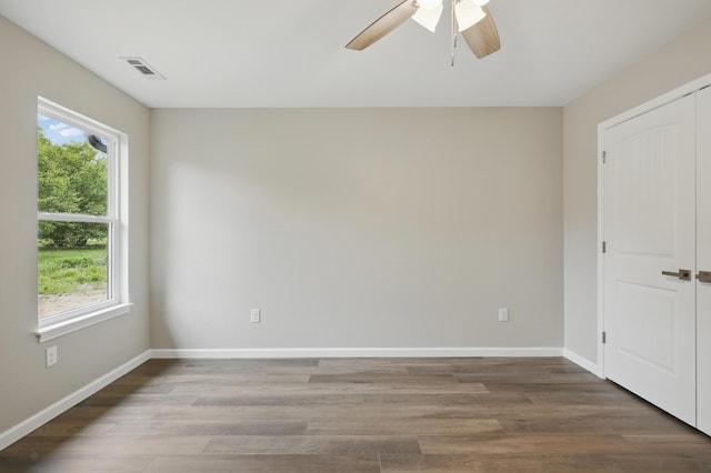 unfurnished bedroom with wood finished floors, baseboards, a ceiling fan, and a closet