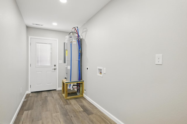 clothes washing area with electric dryer hookup, wood finished floors, water heater, baseboards, and washer hookup