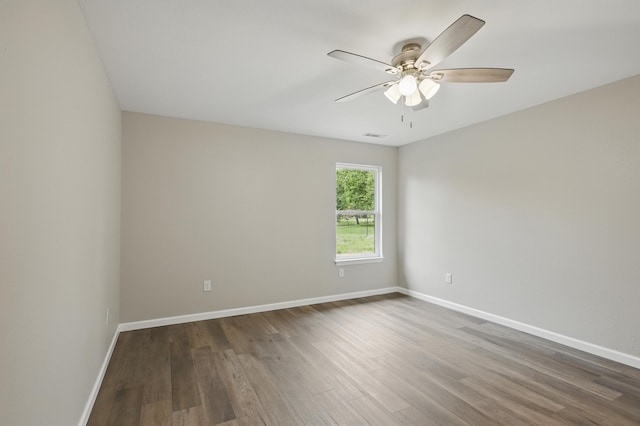 spare room with wood finished floors, ceiling fan, and baseboards