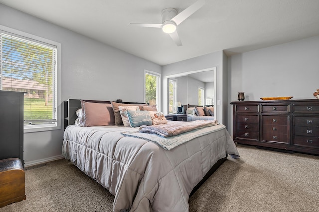 bedroom with light carpet, multiple windows, baseboards, and a ceiling fan