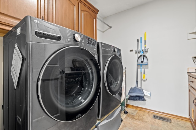 laundry room featuring cabinet space, washer and dryer, and baseboards