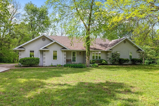 single story home with stucco siding, a front yard, and roof with shingles