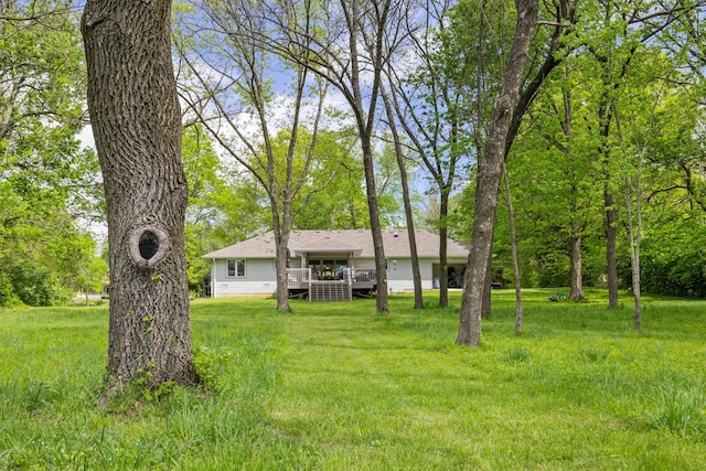 view of green lawn featuring a wooden deck