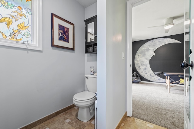 bathroom featuring baseboards, toilet, and ceiling fan