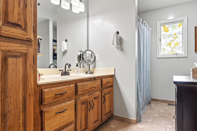full bath featuring baseboards, vanity, stone finish flooring, and a shower with curtain