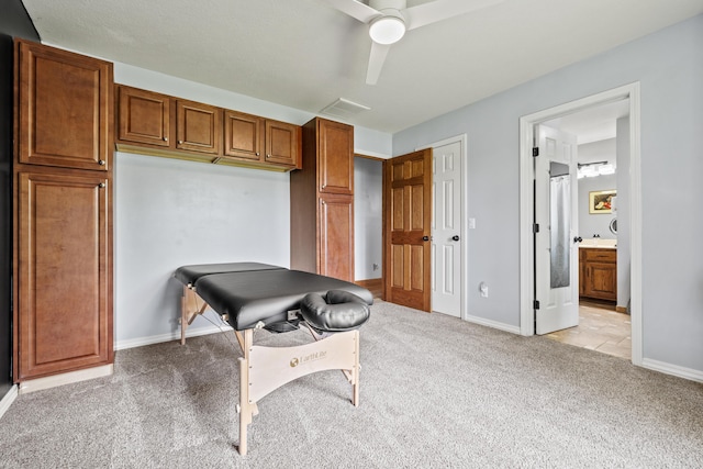 office area with light colored carpet, a ceiling fan, and baseboards