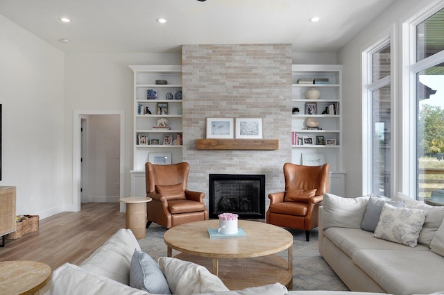 living room featuring plenty of natural light, light wood finished floors, a fireplace, recessed lighting, and baseboards