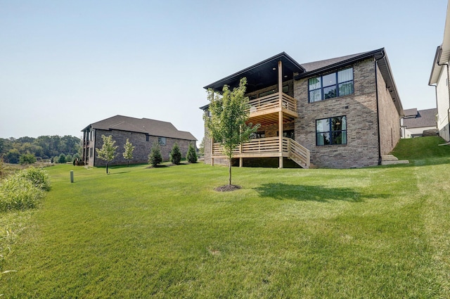 rear view of property featuring a yard, brick siding, a deck, stairway, and a balcony