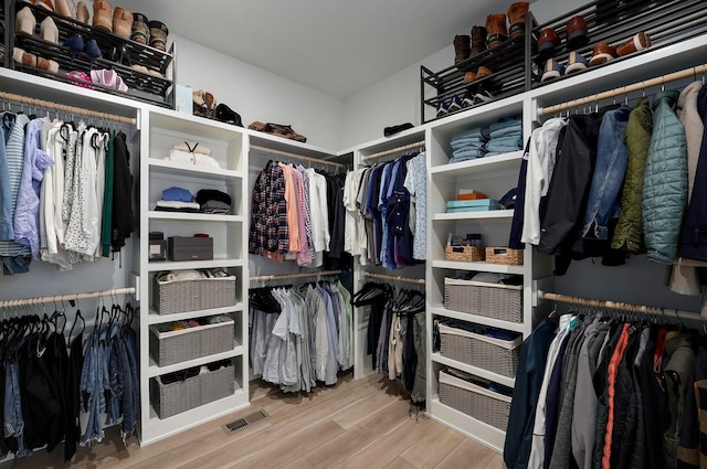 walk in closet with wood finished floors