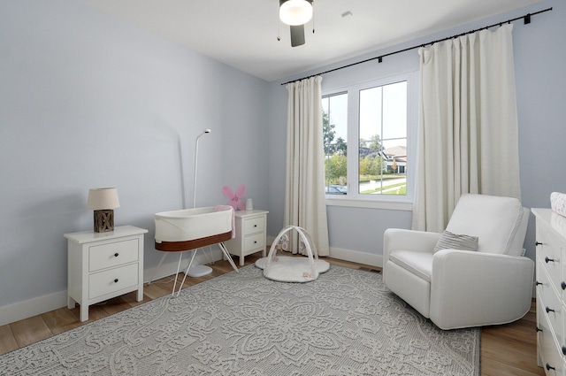 sitting room with light wood-style floors, baseboards, and a ceiling fan